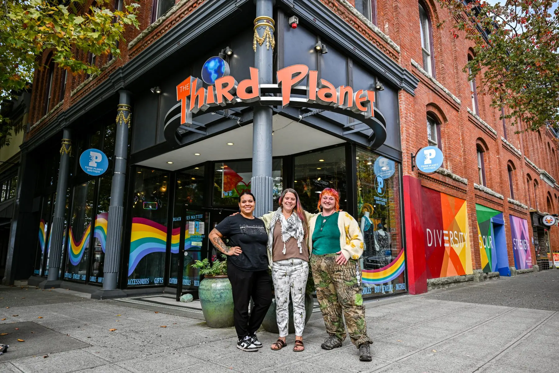 Owner and staff from Third Planet Boutique pose in front of store entrance