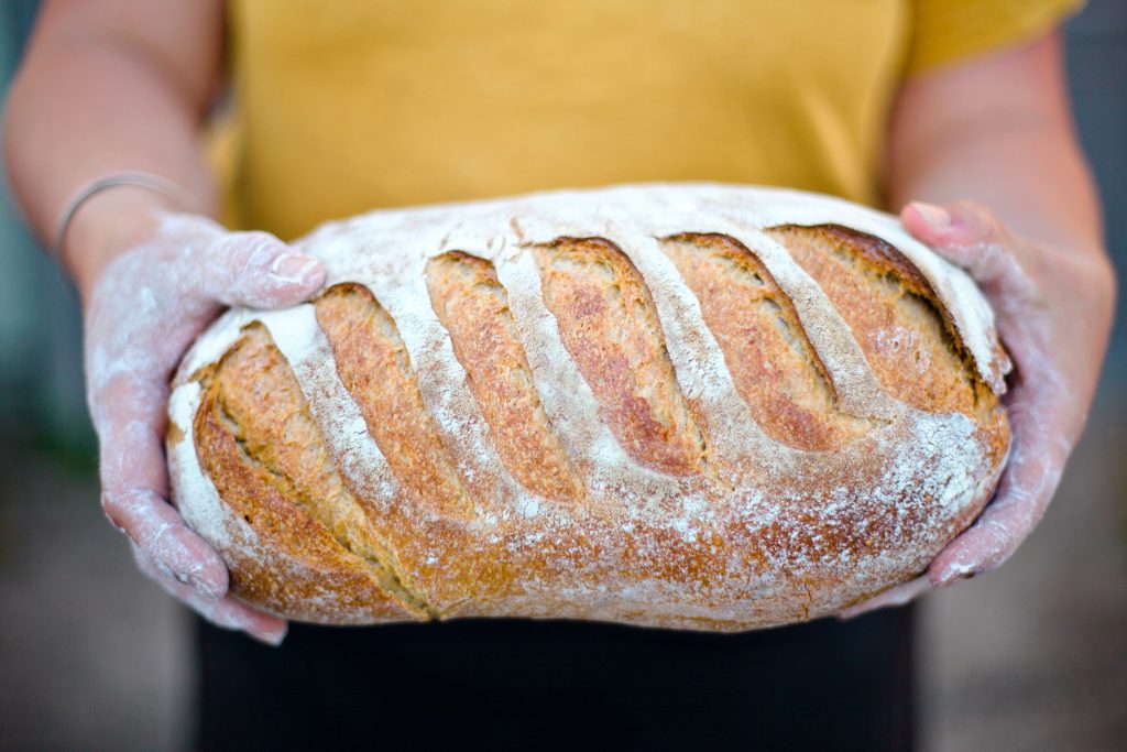 A baker holds a loaf of bread