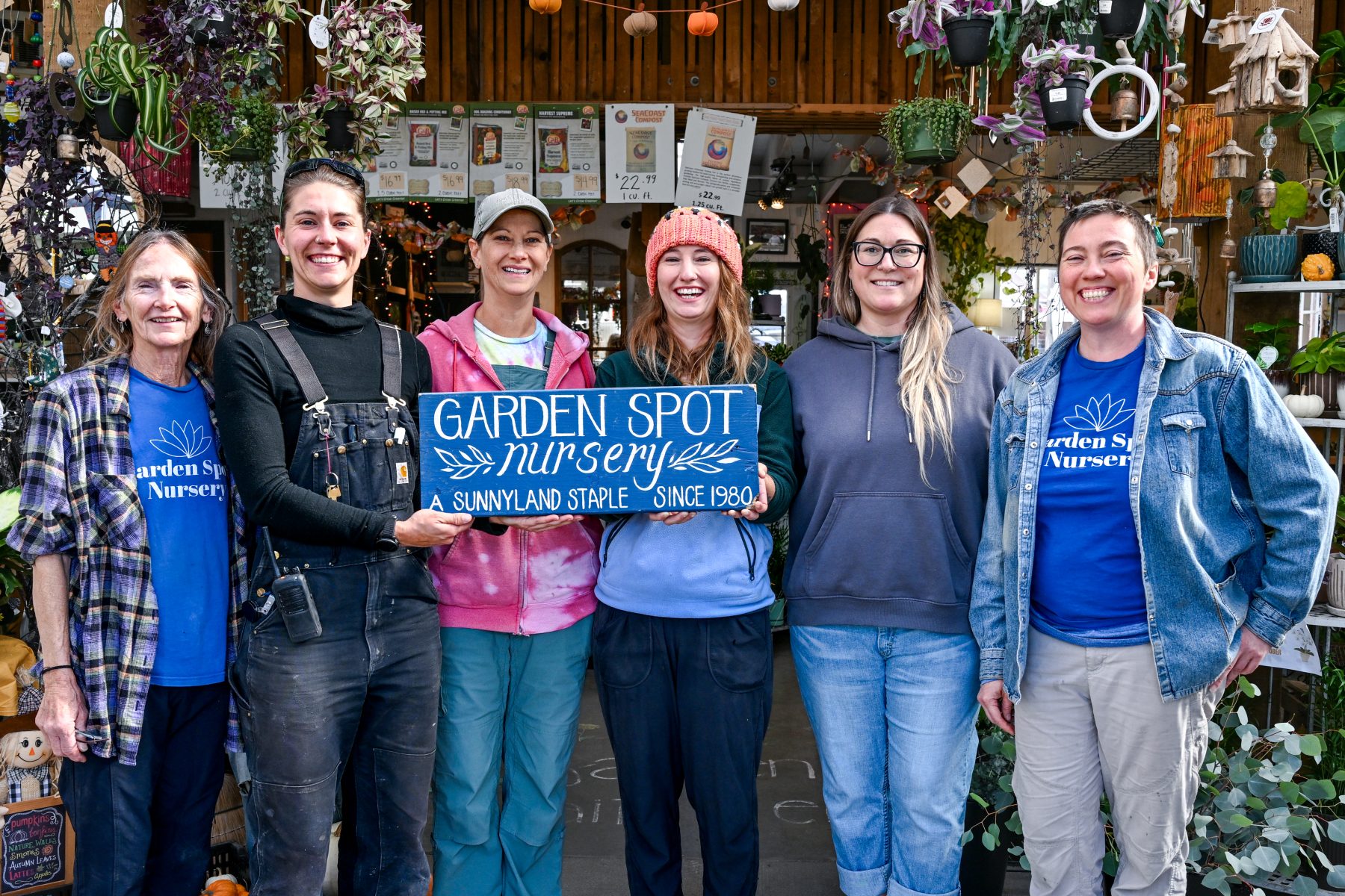 Owner and staff of Garden Spot nursery pose with sign and smile