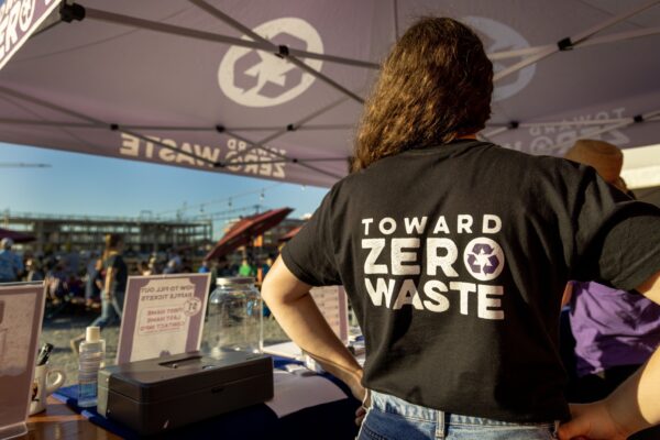 The back of a person’s T shirt that reads “Toward Zero Waste”