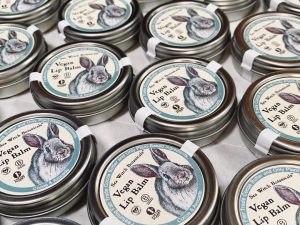 A pile of vegan lip balms and tints from Sea Witch Botanicals, with rabbits on the tins.