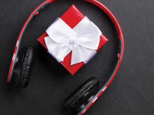 A wrapped present sits between a pair of headphones.